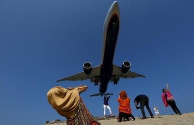  گردشگران در منطقه توریستی پوکت در تایلند در تلاش برای ثبت تصویری ناب از فرود هواپیما در فرودگاه محلی 