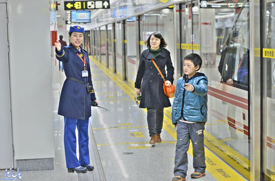 ساعت 8 شب: مامور مترو در حال راهنمایی مسافران/ مامورانی مشخص پیوسته در سالن برای هدایت مسافران و کمک به آنها حضور دارند