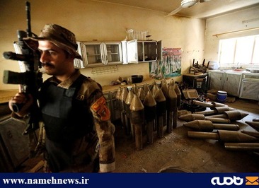سرباز عراقی در کنار سلاح های به جا مانده از تروریست ها