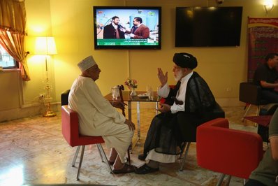 قم در جهان شیعه و اسلام یک شهر مقدس است و مرکز بزرگ تحصیلات دینی به شمار می رود. در این عکس دو روحانی پیش از اقامه نماز در انتظار قهوه هستند.