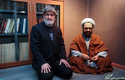 علی مطهری در کنار مجسمه پدرش
